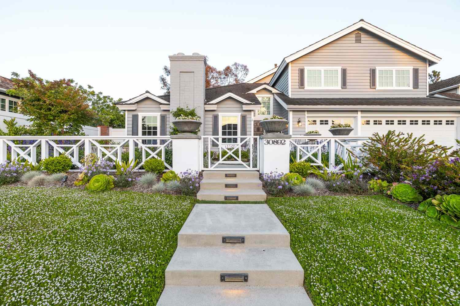 A wellmaintained front yard with a pathway leading to a house
