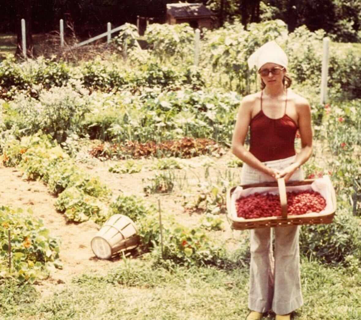 Young decorvow holding a basket of berries in a garden