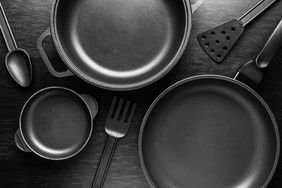 pans and utensils on black background