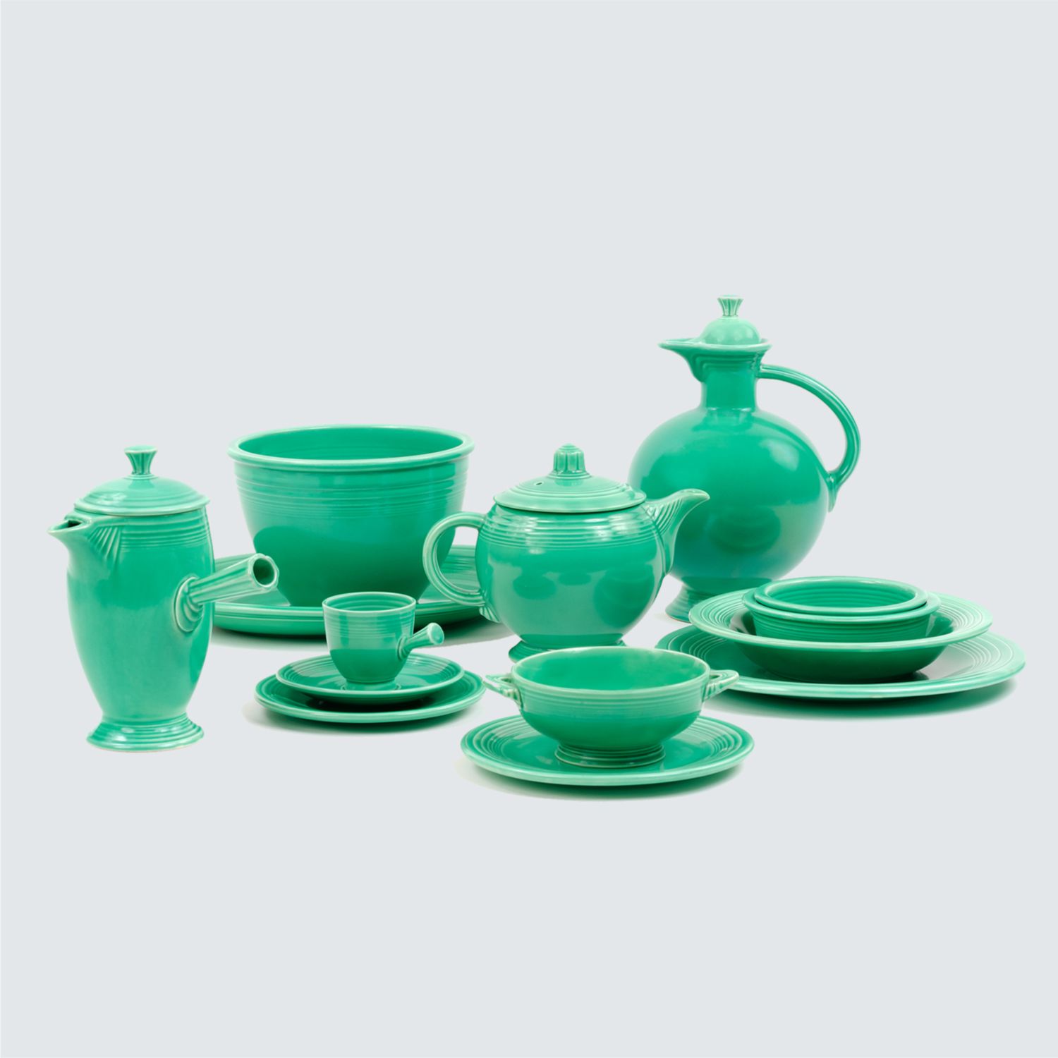A collection of ceramic dishware including plates, bowls, teapots, and cups arranged together