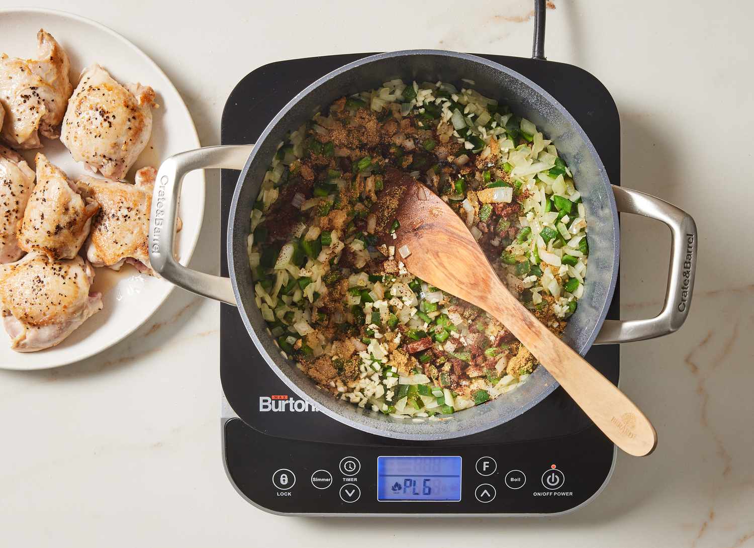 green and white vegetables cooking in a pot with cooked chicken on a plate