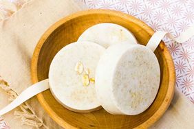 three bars of oatmeal soap in a wooden bowl