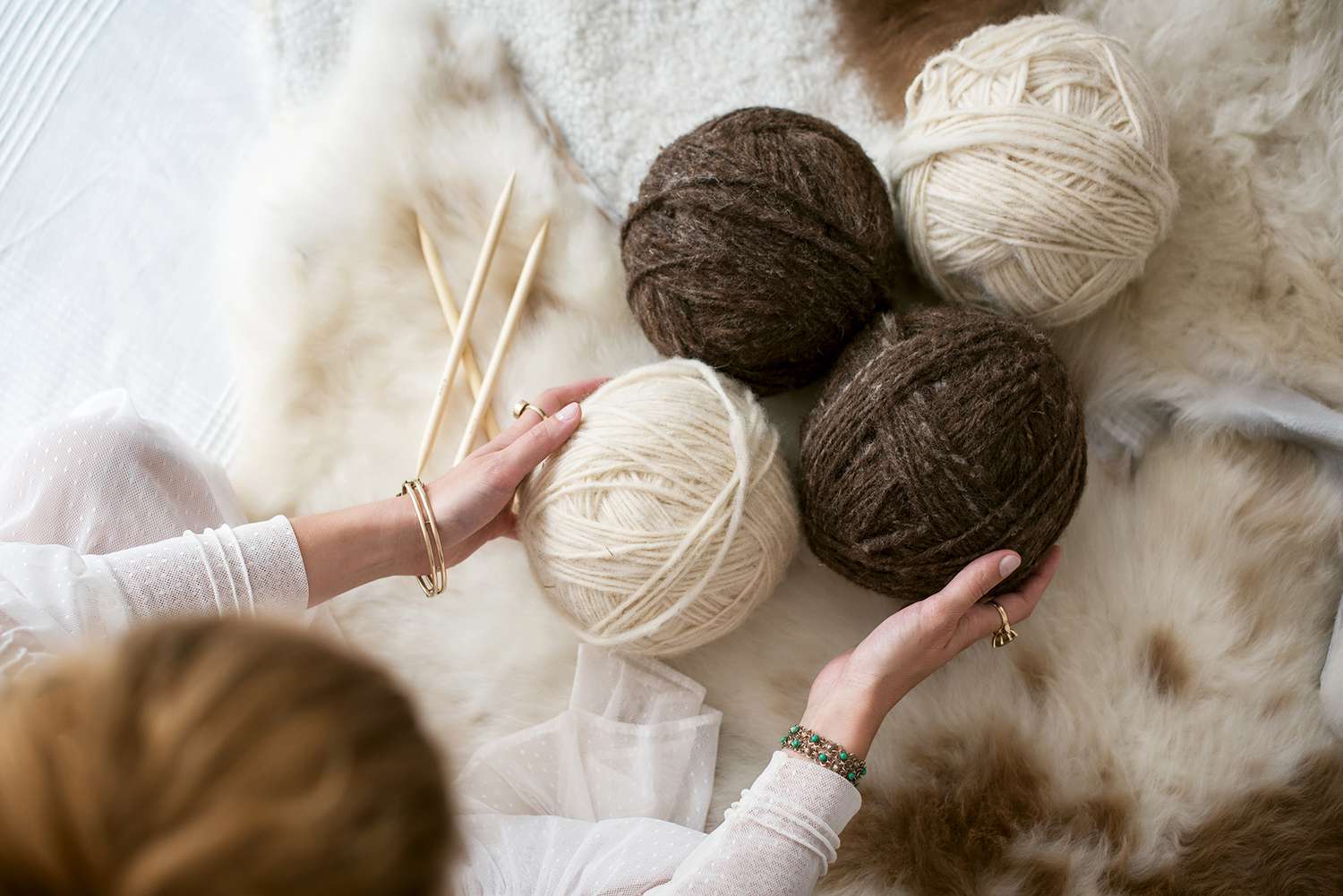 Woman holding onto balls of yarn