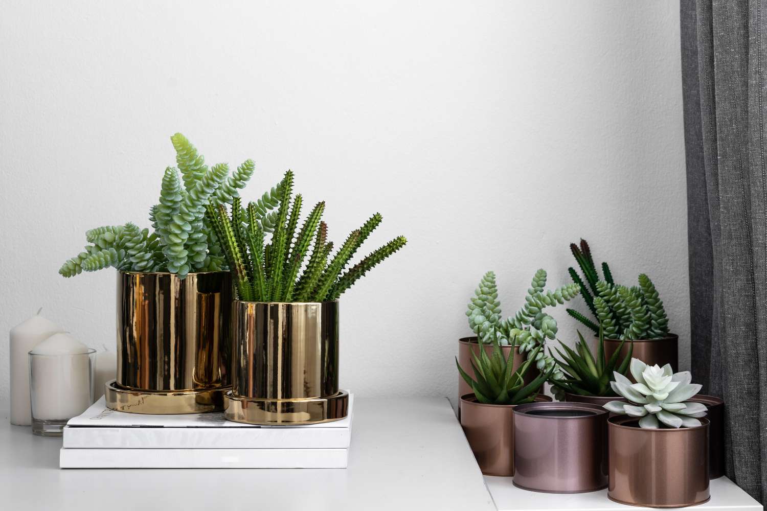 A display of faux plants in metallic planters on a table