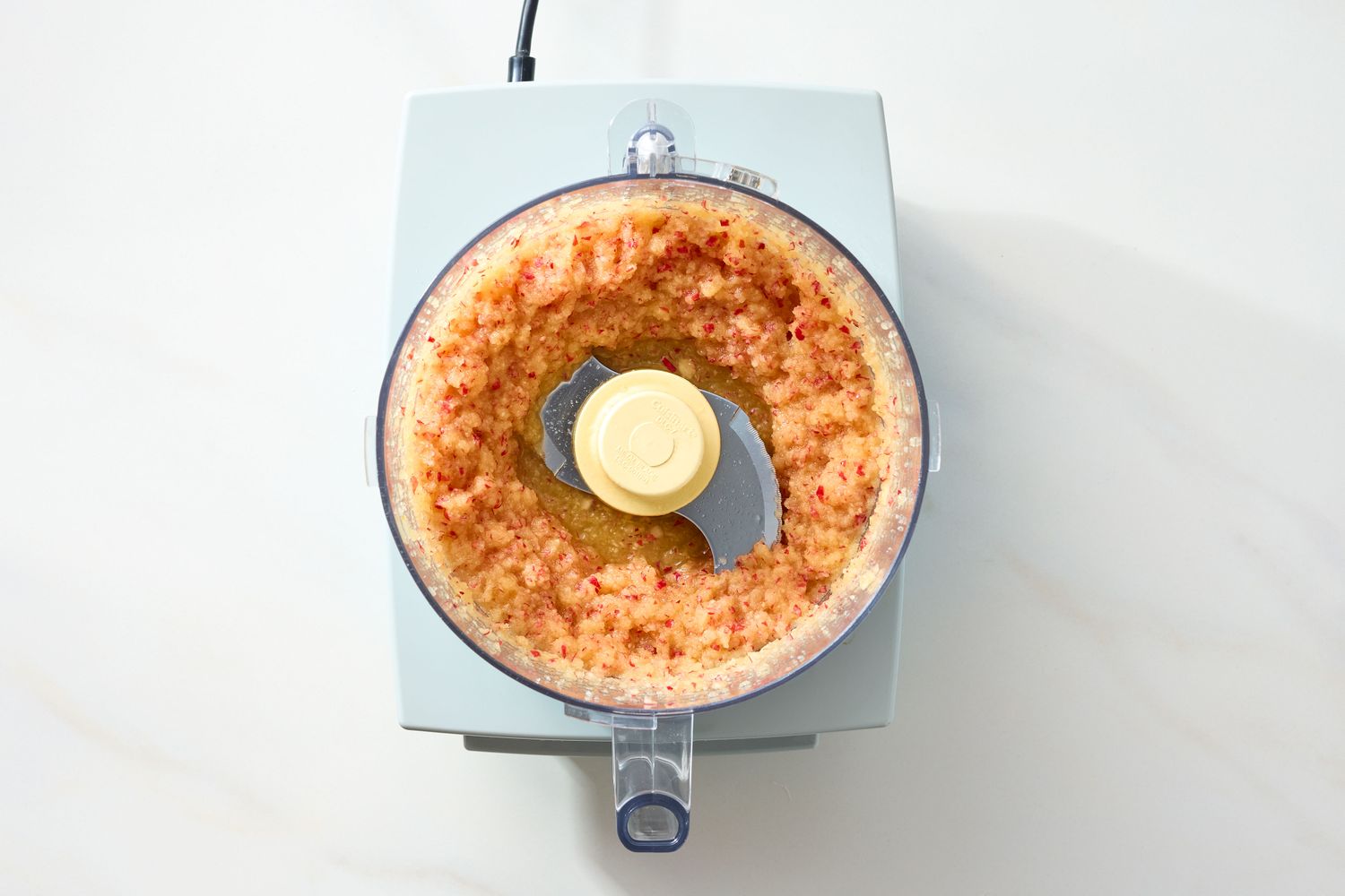 A food processor containing a blended mixture viewed from above