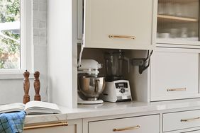 A kitchen appliance garage area with a stand mixer and blender inside a cabinet