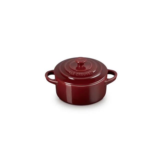 Red mini cocotte with handles and a lid branded as Le Creuset