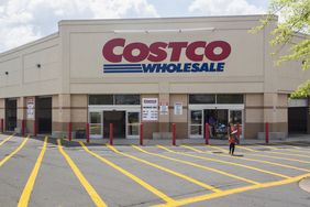 Exterior view of a Costco Wholesale store with a few people near the entrance