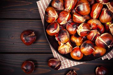 chestnuts in a pan on dark wooden background