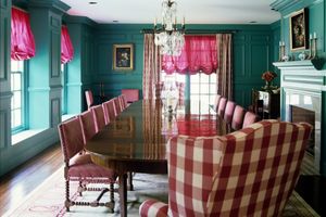 maximalist dining room with teal walls and pink accents