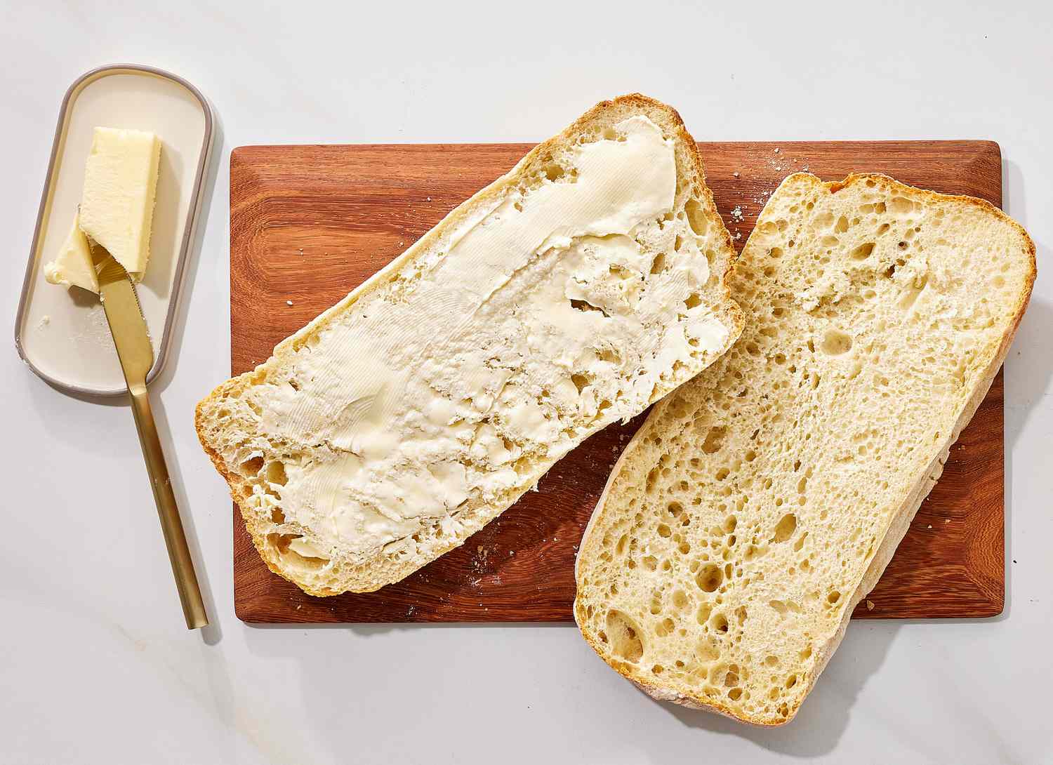overhead view of bread and butter on cutting board