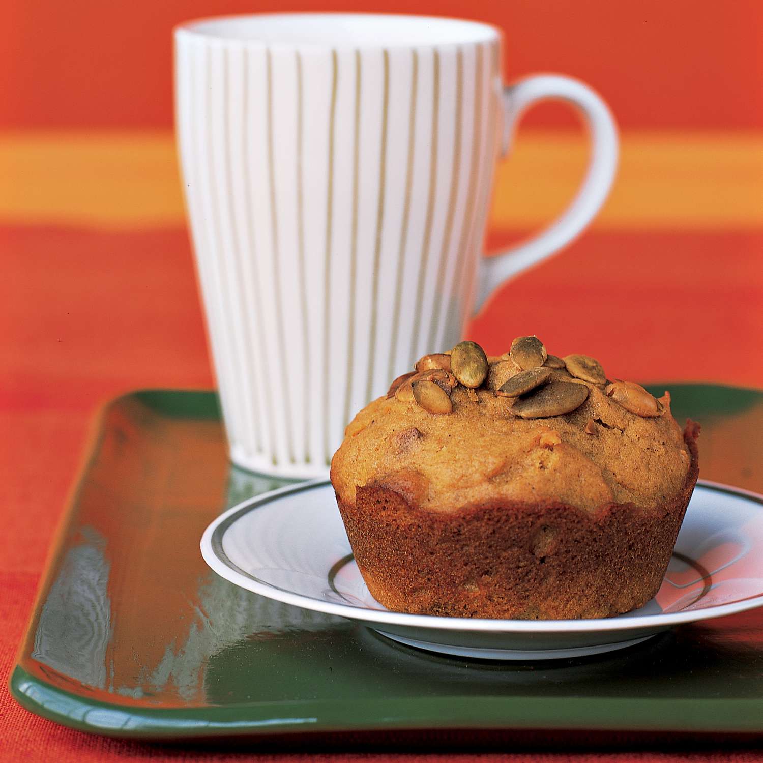 pumpkin seed muffin on a plate with white mug