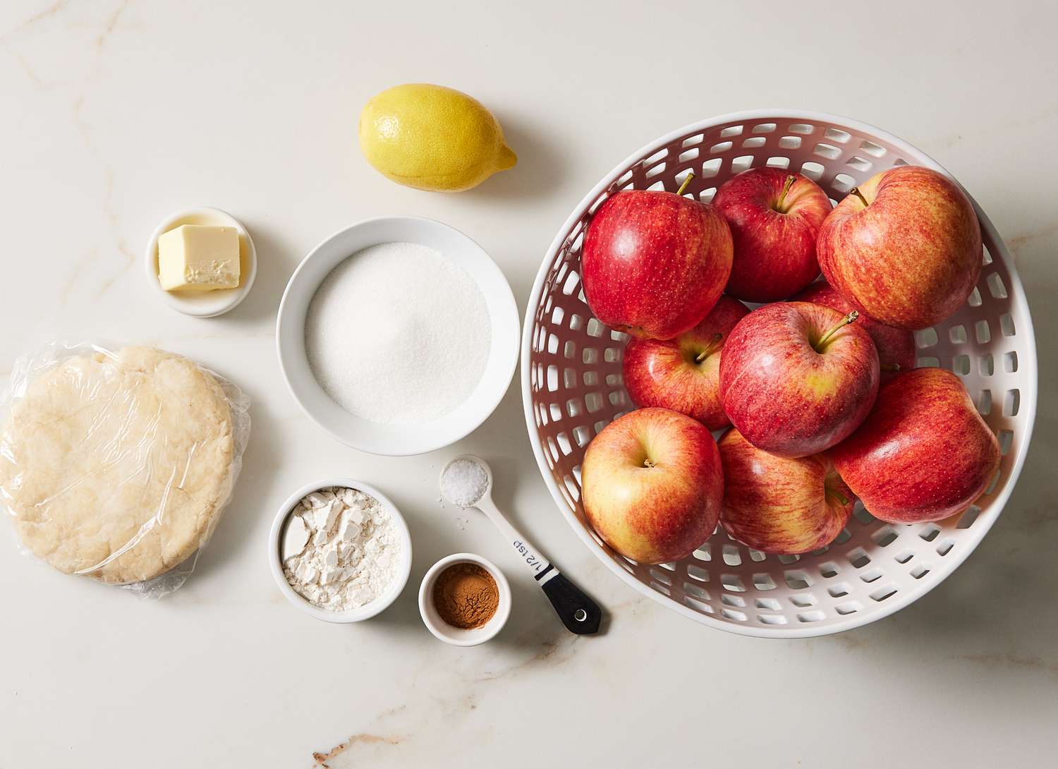 overhead view of apple pie ingredients, bowl of apples and spices, etc