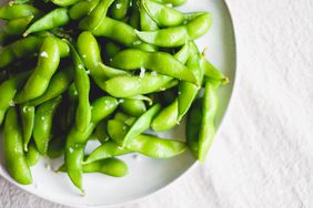edamame pods sprinkled with salt on plate.