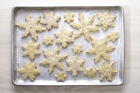 Tray of snowflakeshaped cookies with various patterns of decoration