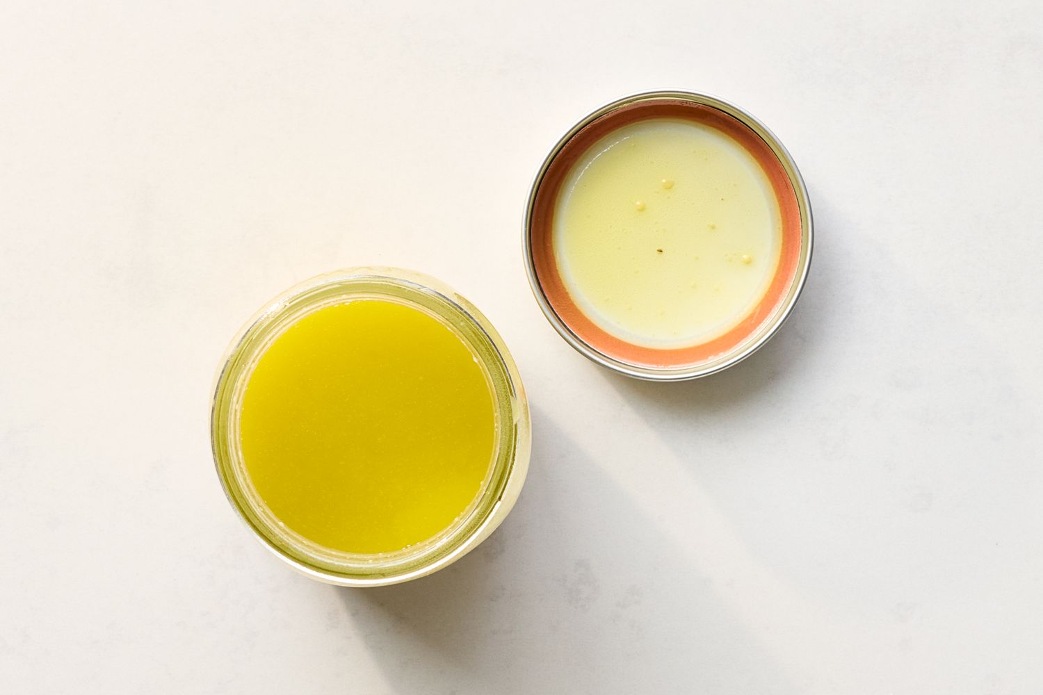 A jar of vinaigrette with its lid beside it on a flat surface