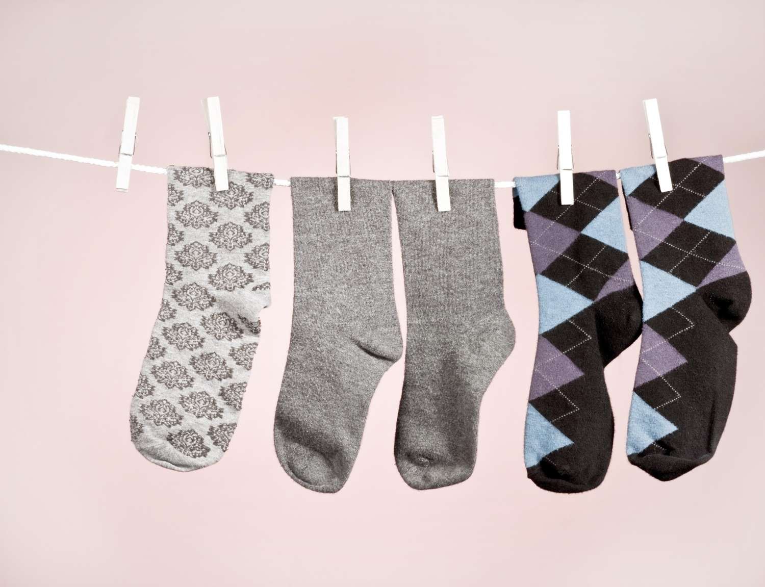 Four socks hanging on a clothesline using clothespins