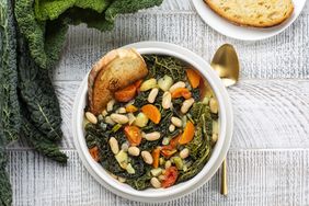 Tuscan soup with white beans kale in a bowl on textured surface