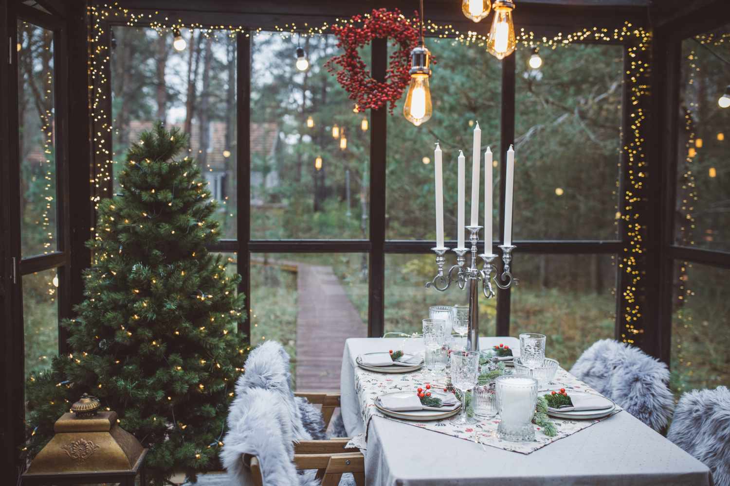 Table at cottage green house decorated for Christmas dinner.