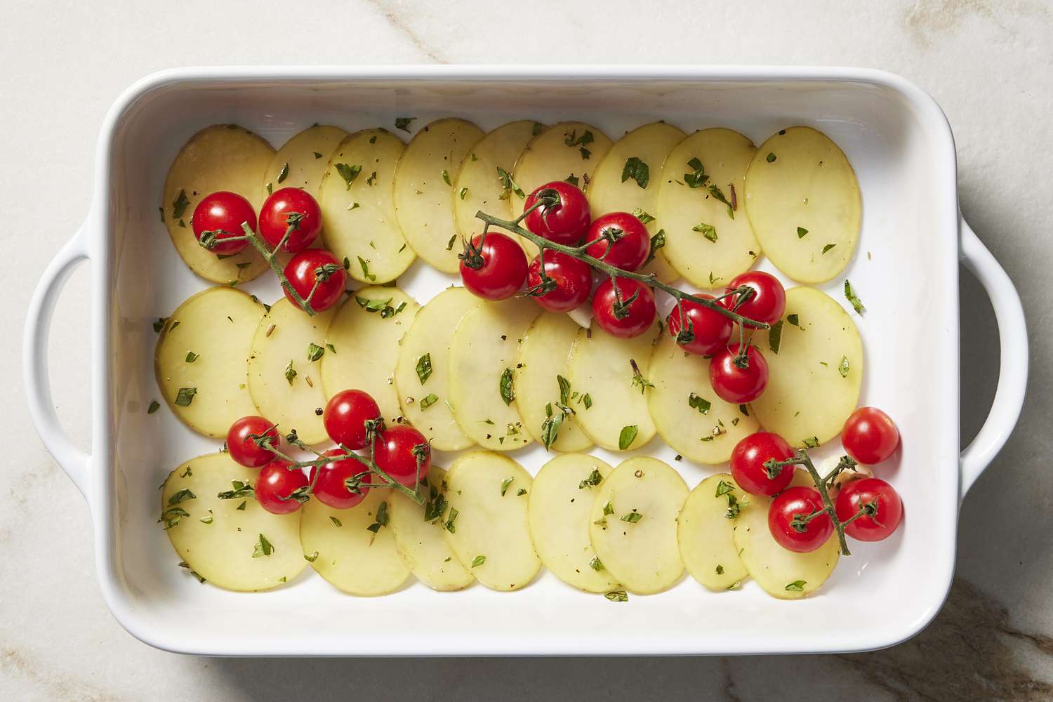 Potatoes and cherry tomatoes in baking pan