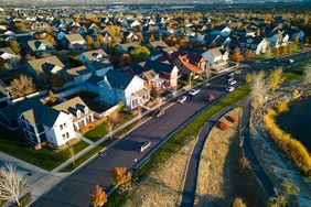 A residential neighborhood with houses roads and a visible water body or park on the side
