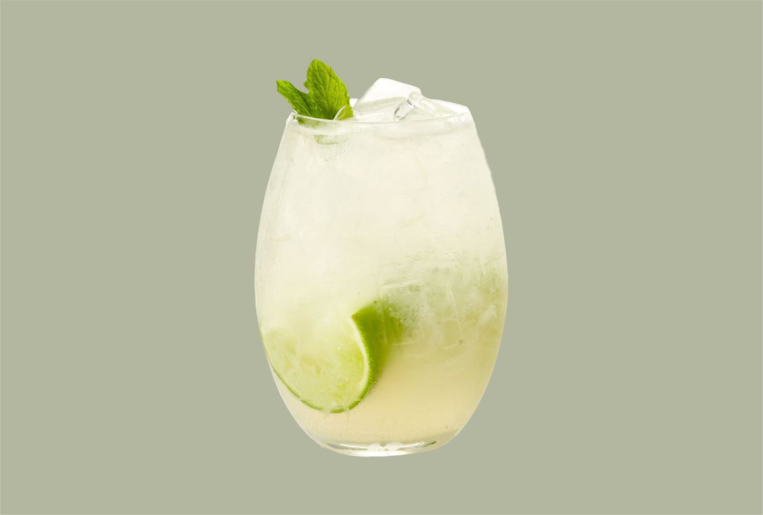 stemless glass with cocktail lime and mint on green background
