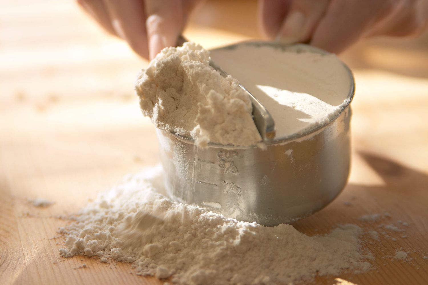 discarding extra flour from measuring cup