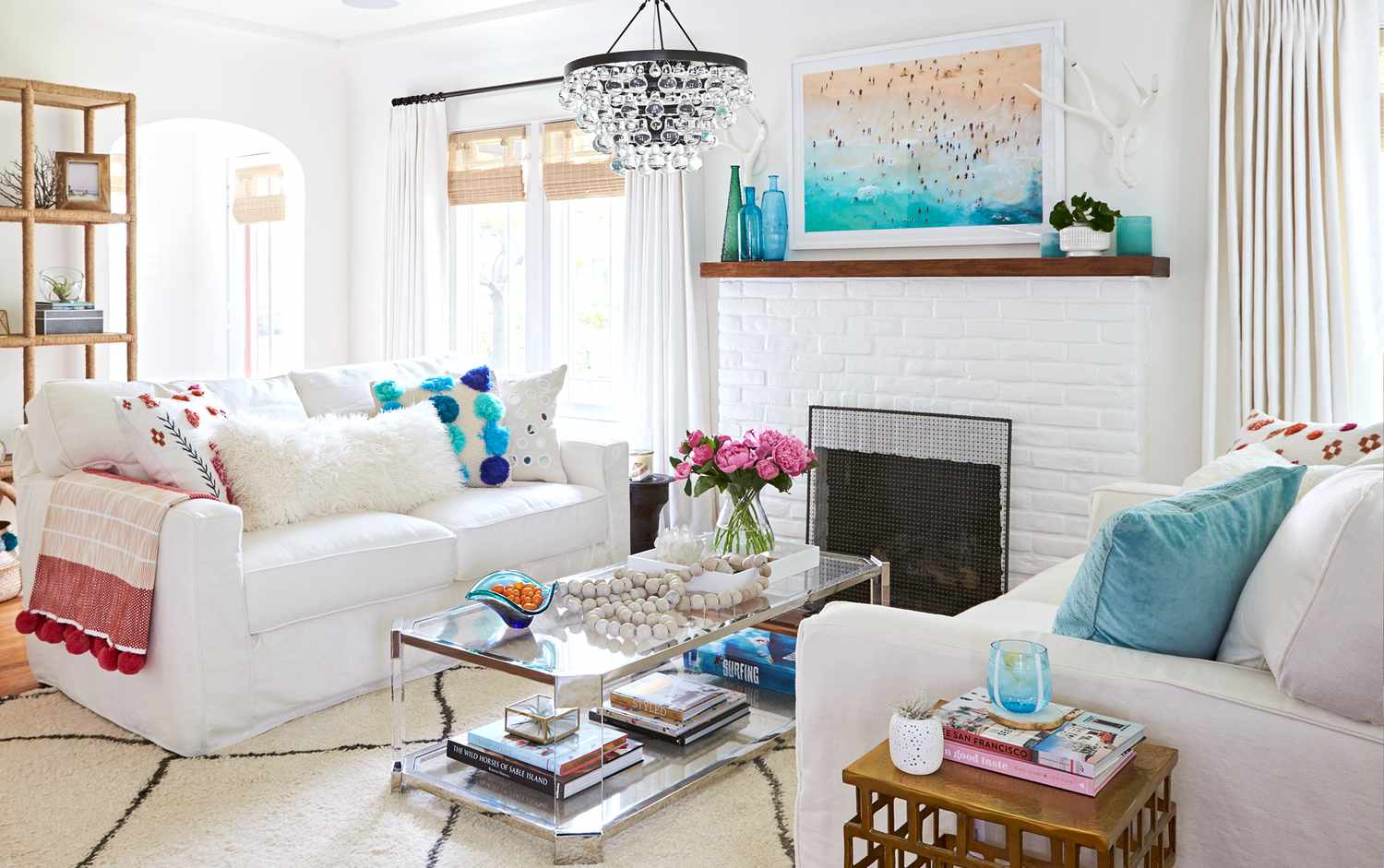 A coastal-style living room with bright white furniture and turquoise accents.