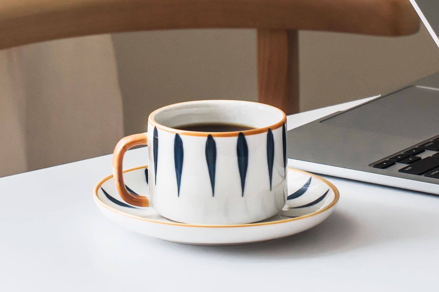 Coffee mug on desk next to laptop