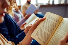 Group of people reading books together in a room