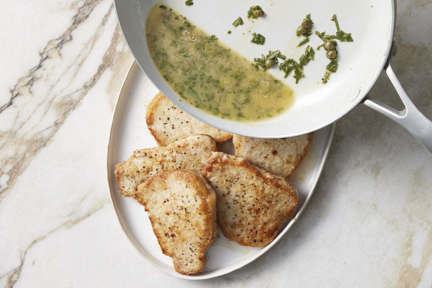 Butter being poured over sautÃ©ed pork