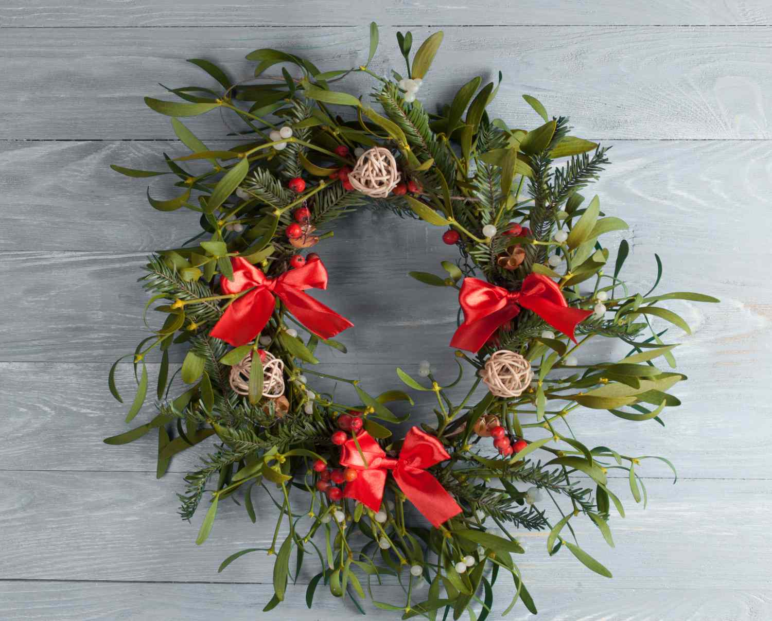 Christmas wreath with mistletoe on wood board