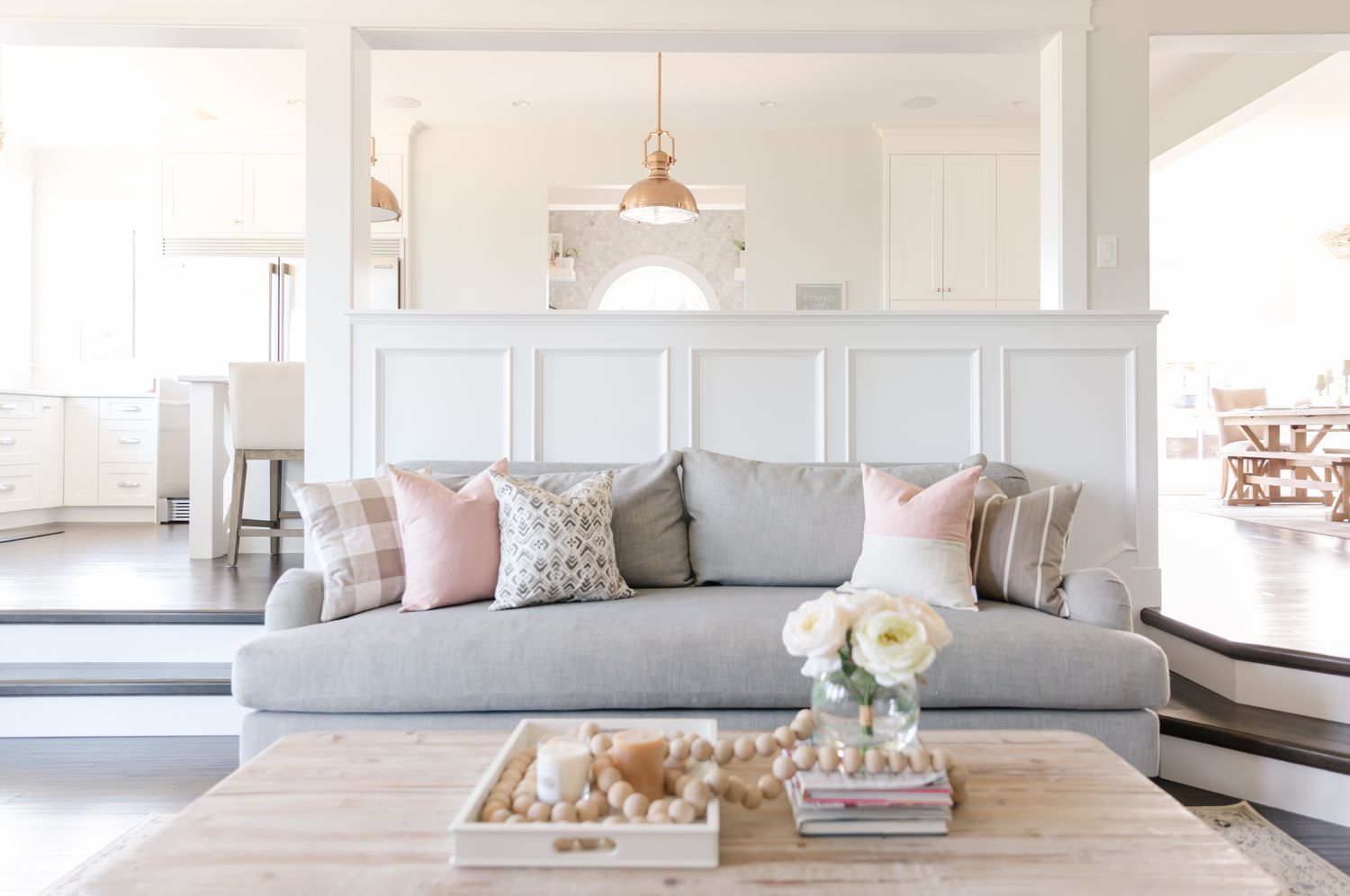 Living room setup with a sofa throw pillows and a coffee table with decor items part of an openplan home interior