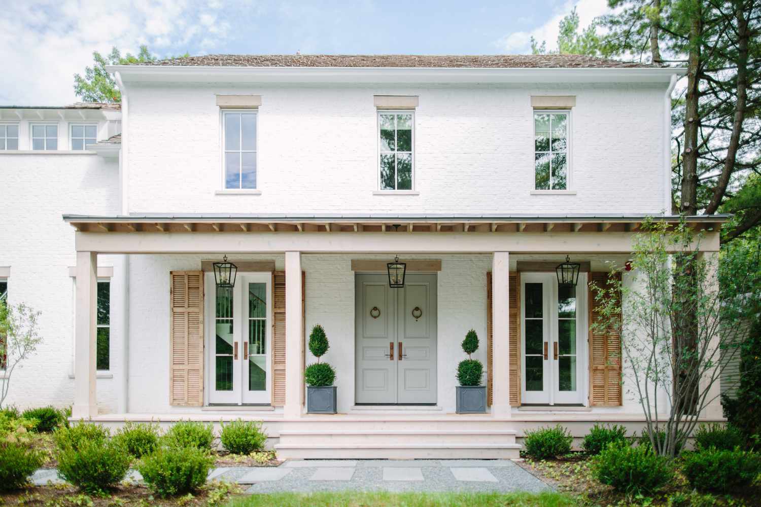 A white house with a sage French-style front door