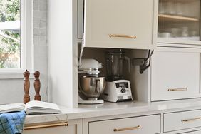A kitchen appliance garage area with a stand mixer and blender inside a cabinet