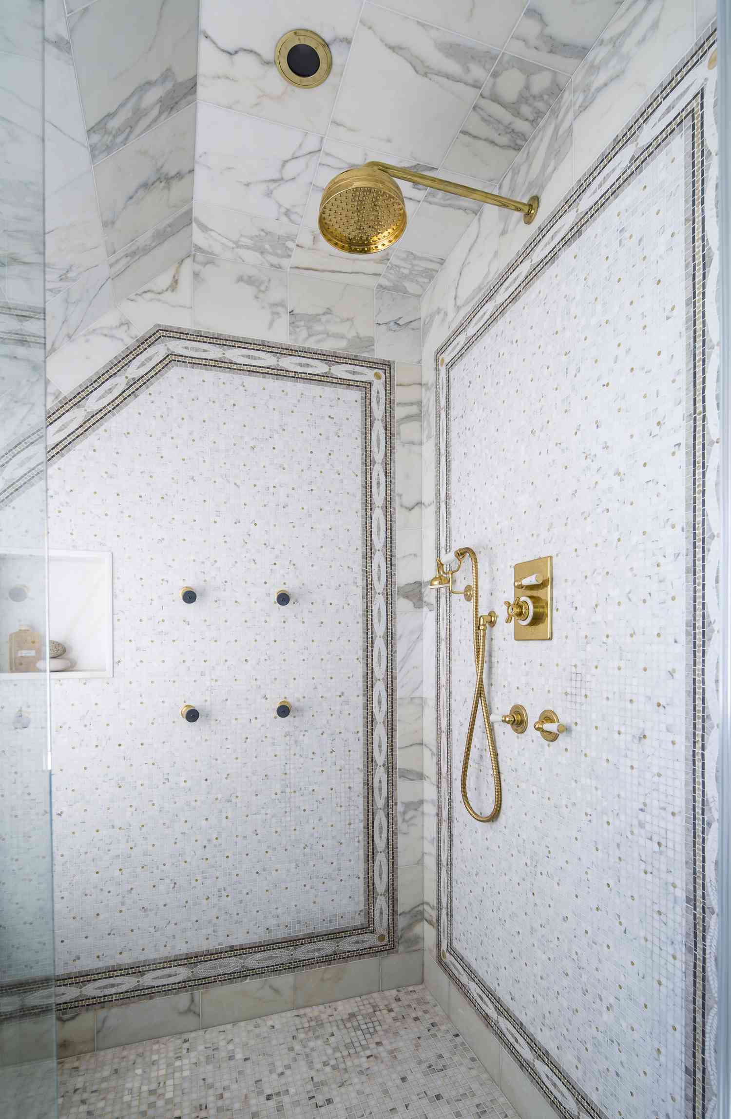 a whit walk-in shower with intricate tile