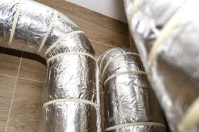 Insulated ventilation ducts installed on a tiled floor