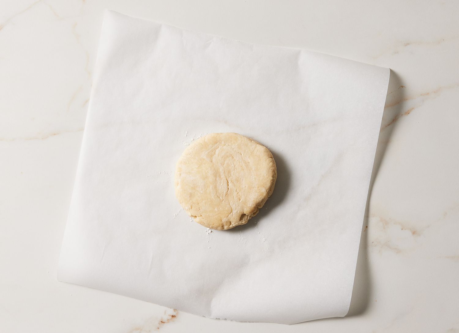 overhead view of pie dough ball on parchment paper