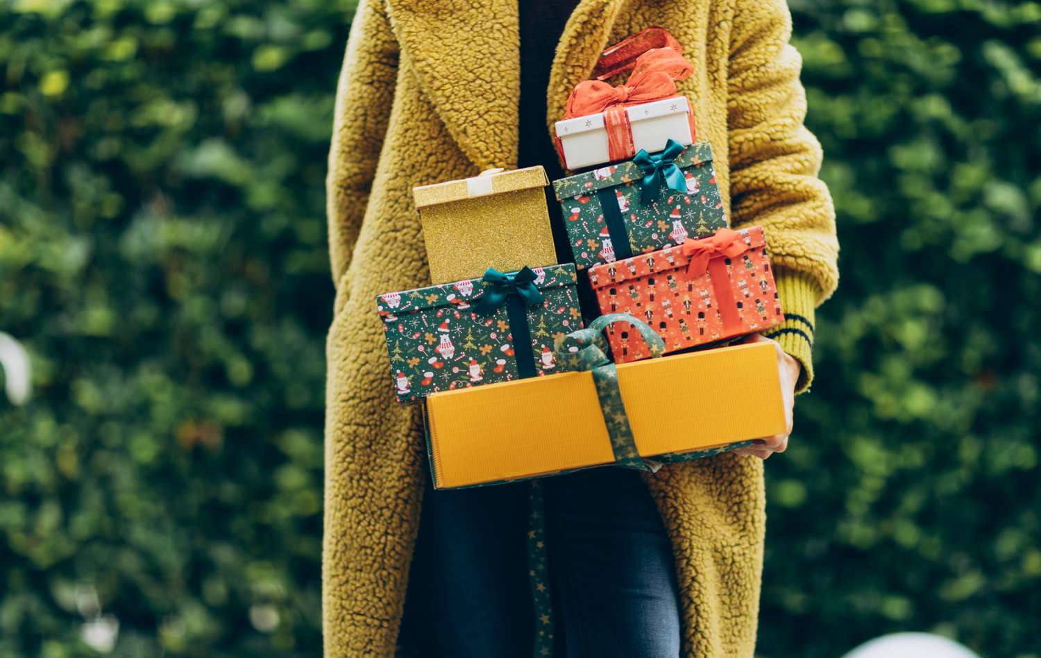 Woman holding stack of holiday gifts