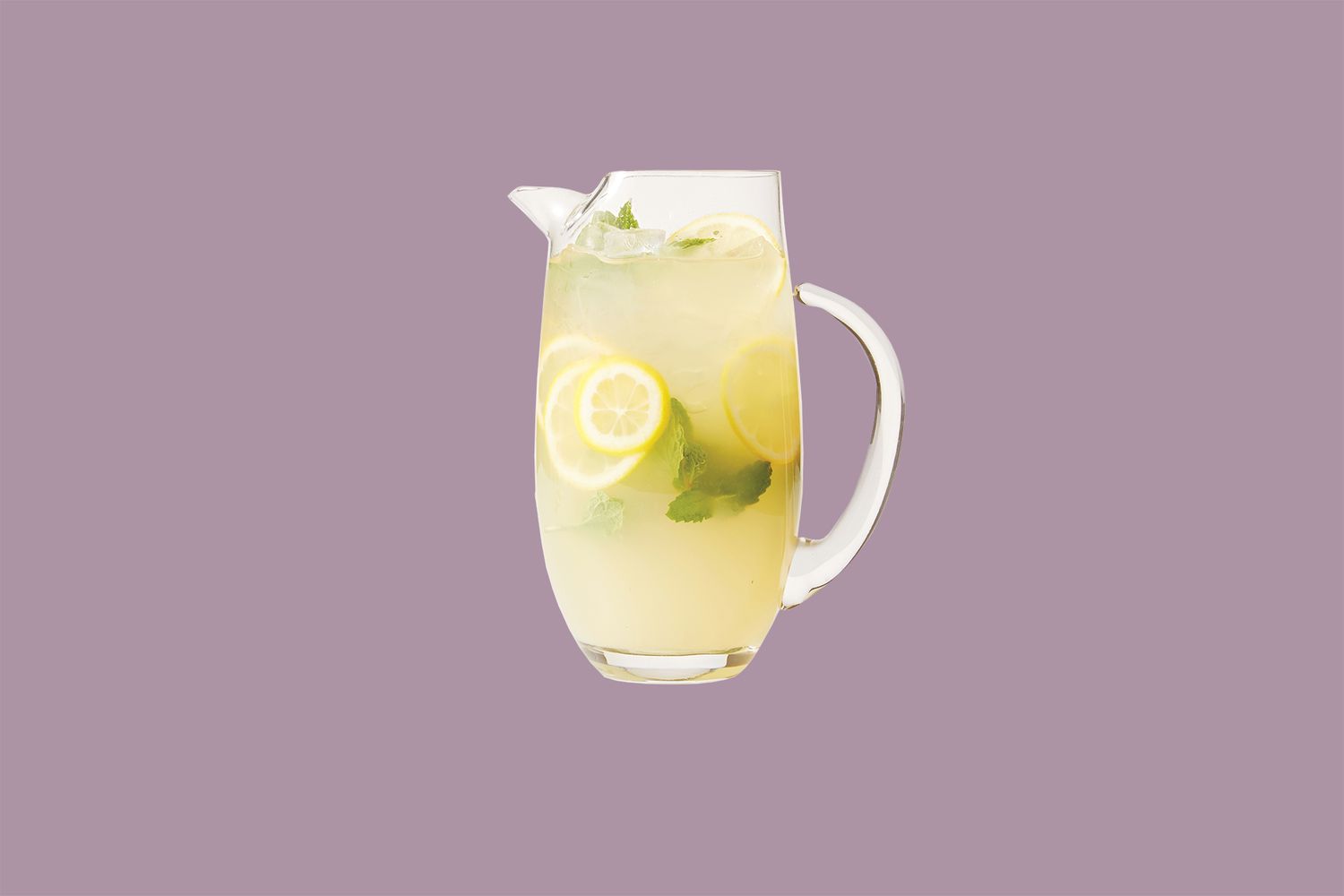 glass pitcher of lemonade with mint leaves and sliced lemons