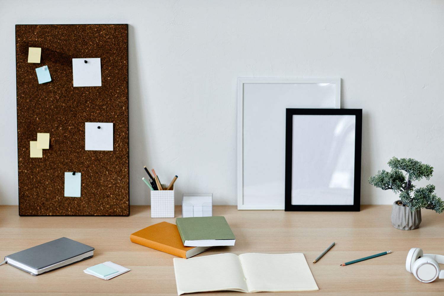 Home office desk with corkboard and whiteboard and notebooks