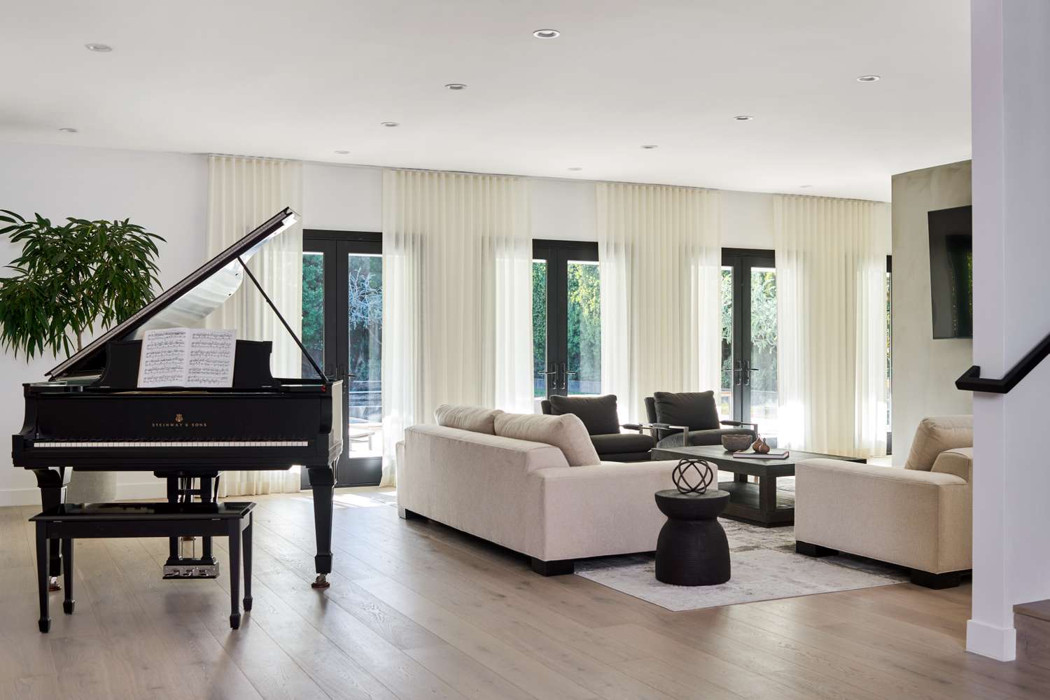 Layered sheer curtains in a modern living room with a grand piano