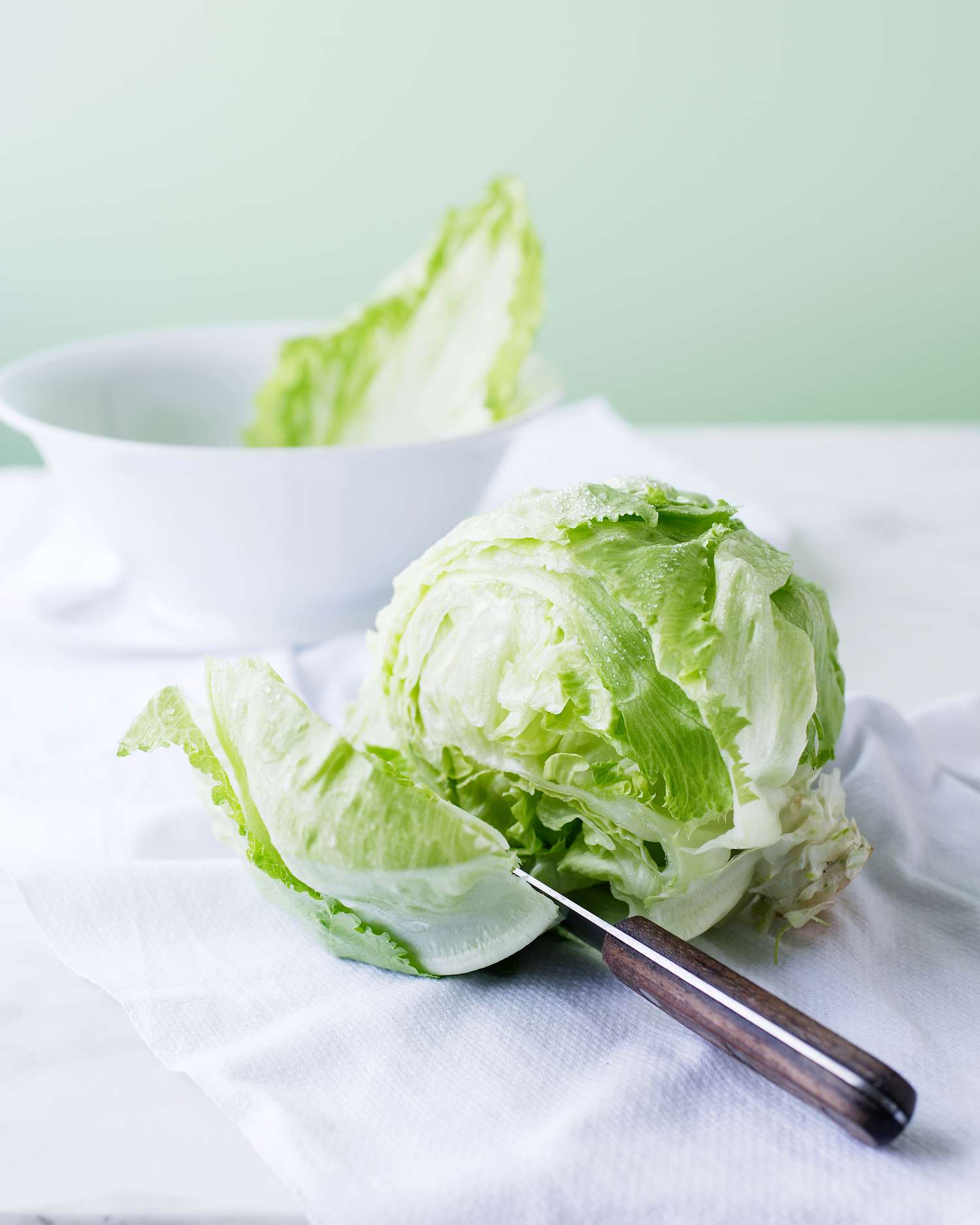 iceberg lettuce with a knife and a bowl