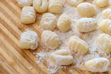 Homemade gnocchi with flour on a wooden countertop