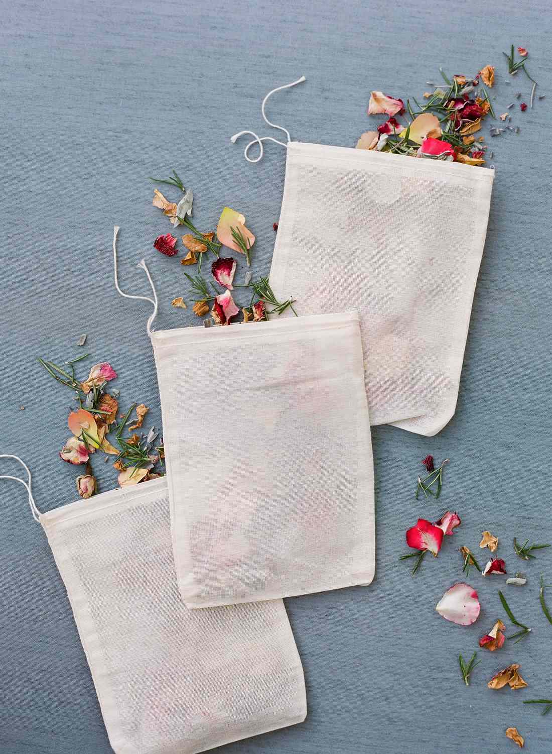 white pouches filled with dried flower petals and herbs