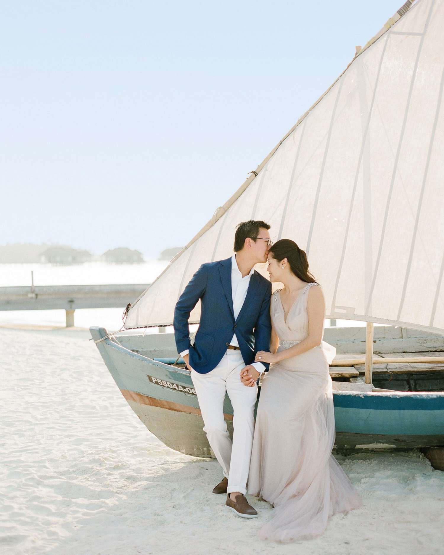peony-richard-wedding-maldives-couple-by-sailboat-sand-kiss-0632-s112383.jpg