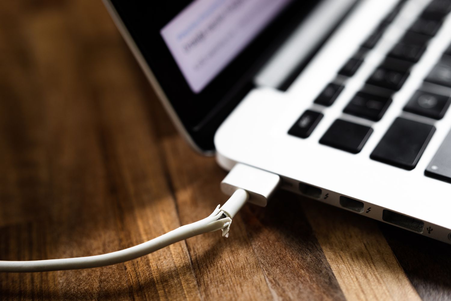 Frayed charging cable connected to laptop