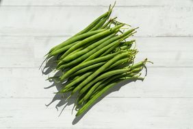 fresh green beans on white surface
