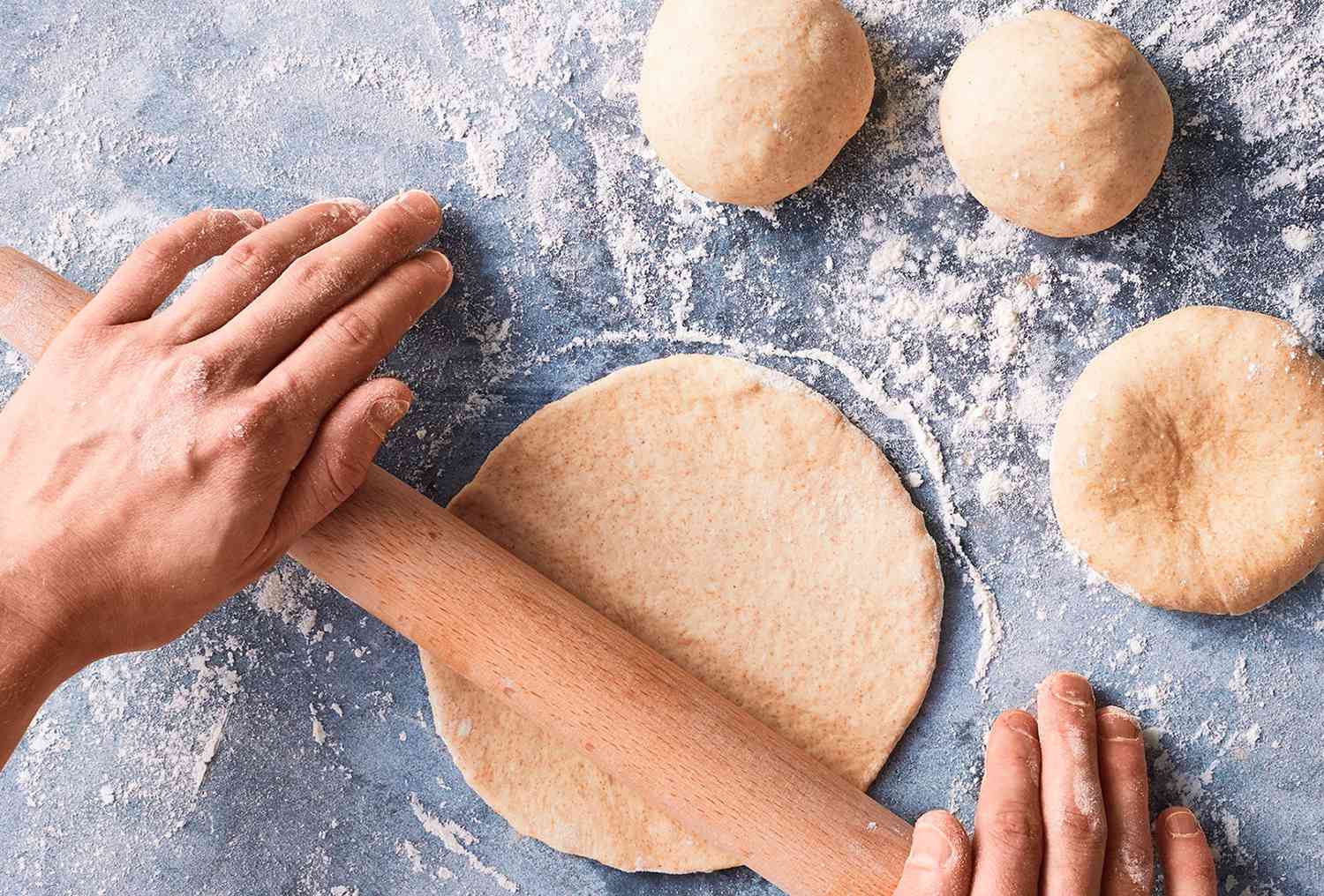 Bread being rolled with rolling pin