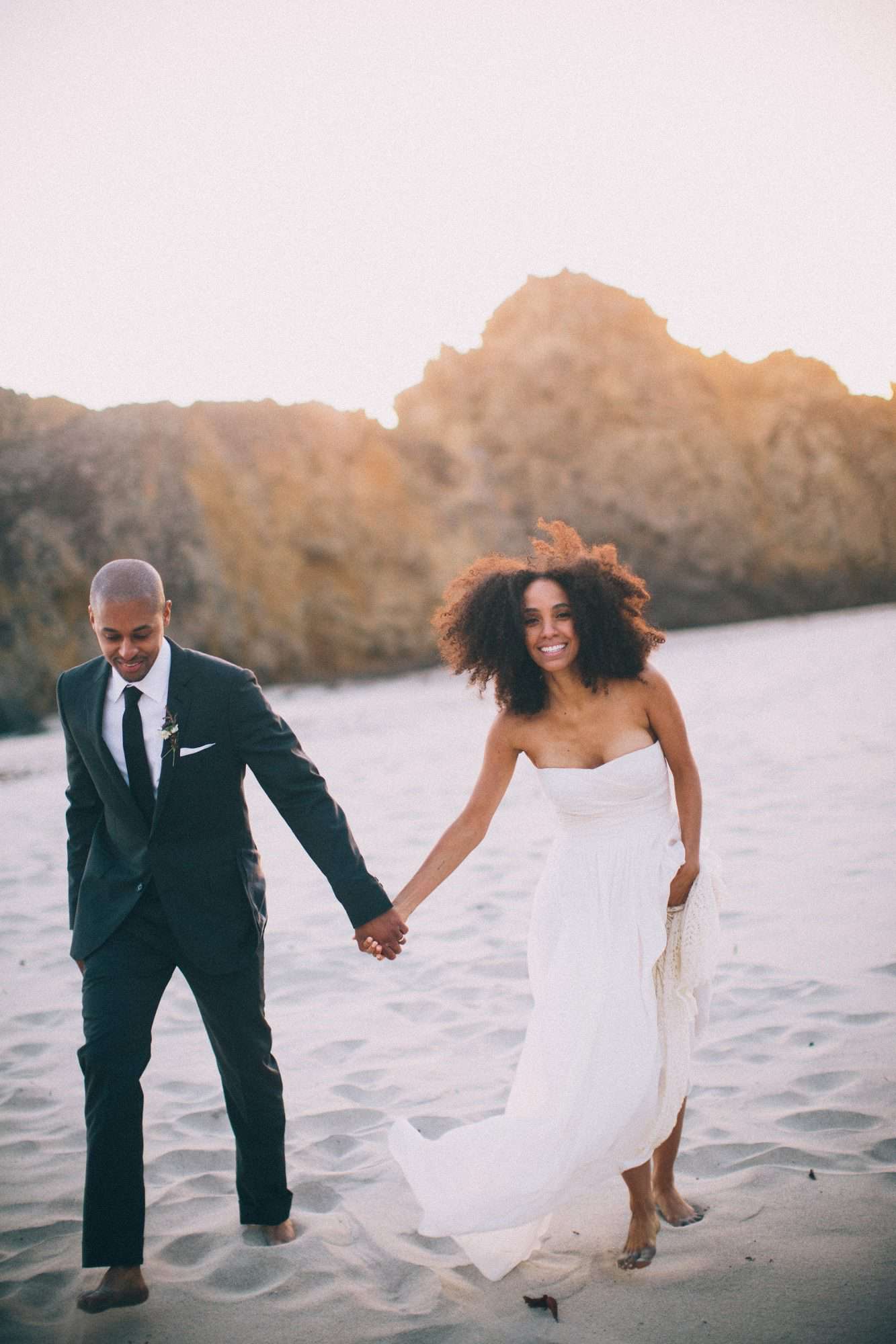 beach wedding dresses bride and groom holding hands walking on the beach